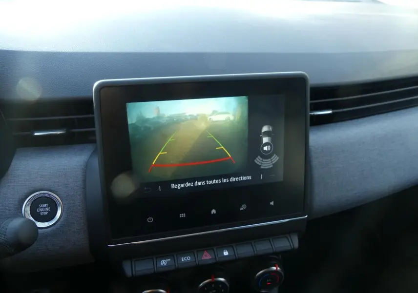 Écran tactile central affichant la caméra de recul dans l'habitacle de la Renault Clio gris schiste, vue de face.