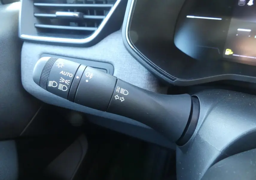 Gros plan sur la manette de commande des feux et clignotants dans l'habitacle gris de la Renault Clio 2025.