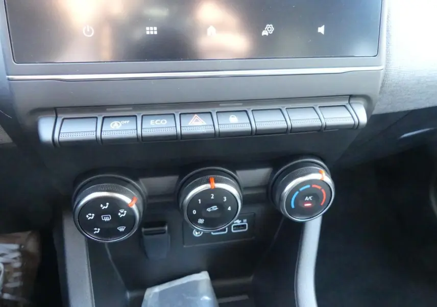 Gros plan sur la console centrale de la Renault Clio 1.5 Blue dCi 2025 avec commandes de climatisation et boutons fonctionnels.