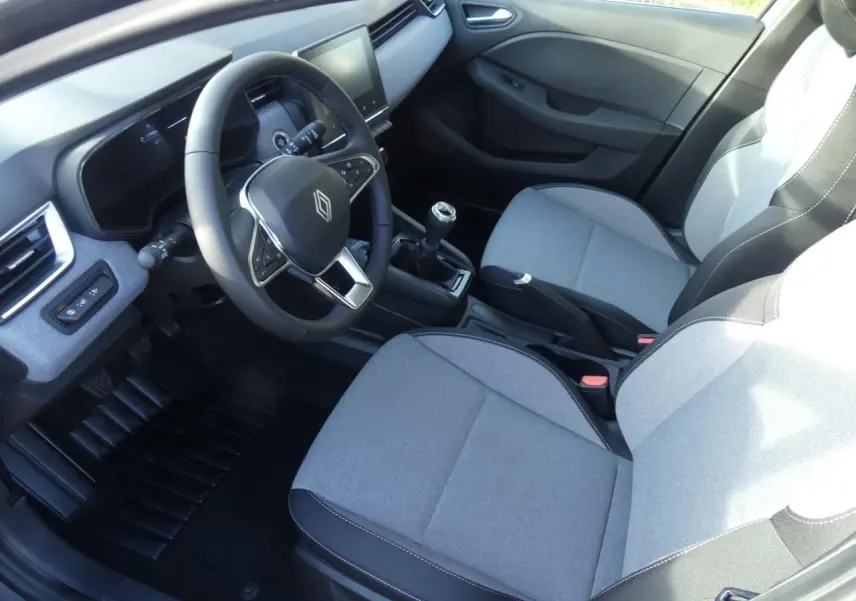 Vue intérieure côté conducteur de la Renault Clio 1.5 Blue dCi 2025 avec sièges tissu gris et volant multifonction.