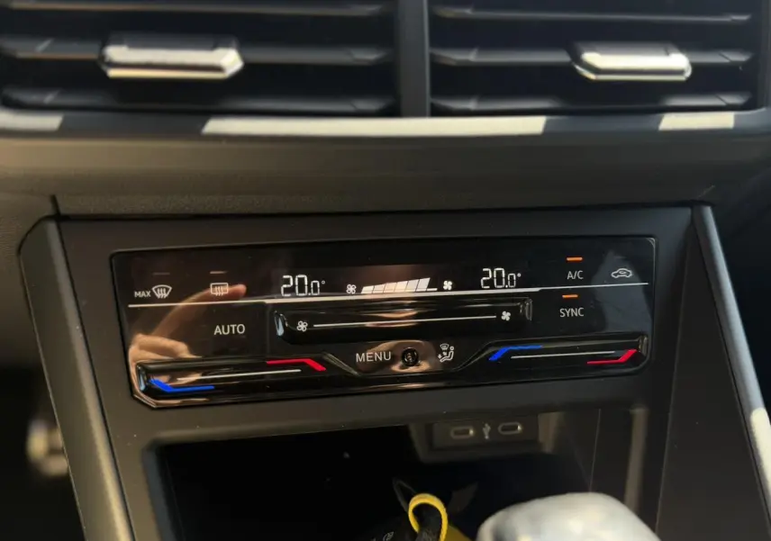 Gros plan sur la commande de climatisation automatique bi-zone du Volkswagen Taigo noir, affichant 20°C des deux côtés.