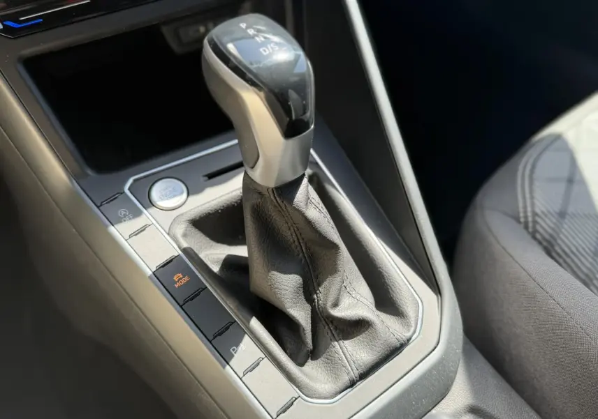Gros plan sur le levier de vitesses automatique noir et argenté du Volkswagen Taigo TSI 116 DSG R-Line, avec bouton de démarrage visible.