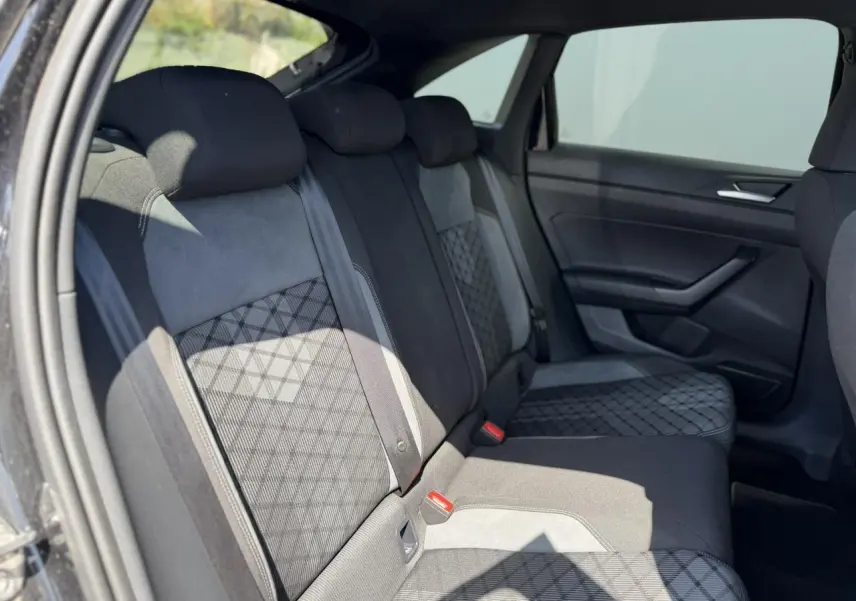 Vue côté droit de la banquette arrière noire avec sellerie tissu R-Line et motifs géométriques dans un Volkswagen Taigo 2025.