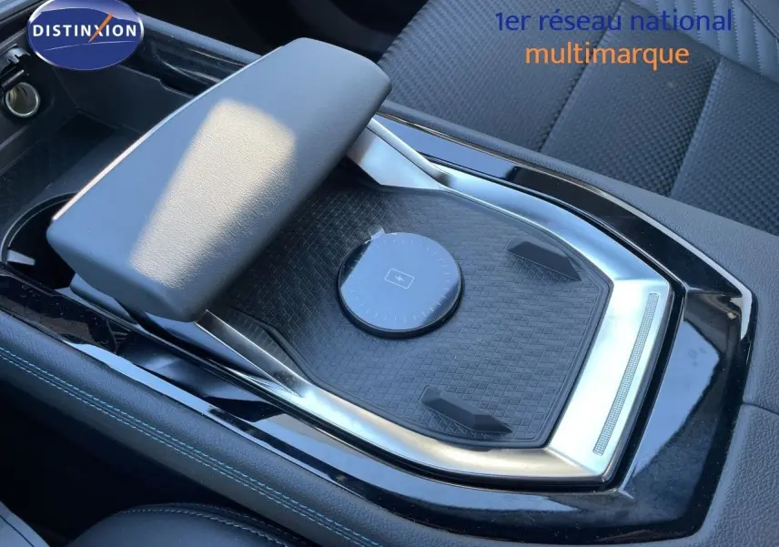 Gros plan sur la console centrale noire avec accoudoir et surface de recharge sans fil du Renault Austral E-Tech 2026.