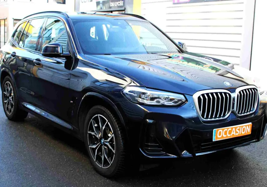 BMW X3 xDrive 30e bleu métal en 3/4 avant droit, avec calandre double haricot et jantes M Sport visibles.
