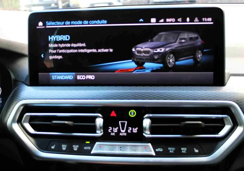 Écran central du BMW X3 xDrive 30e 2023 affichant le mode hybride avec vue 3/4 avant du SUV bleu métal.