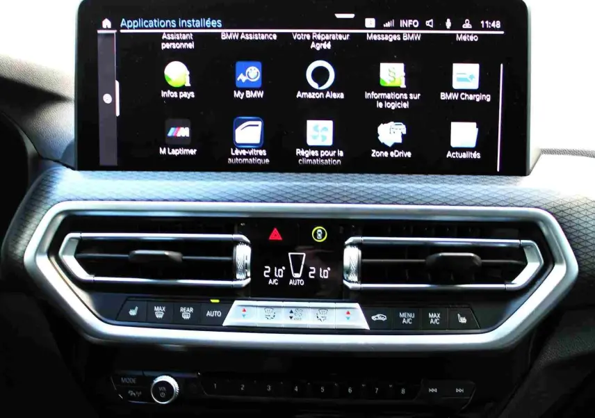 Tableau de bord du BMW X3 xDrive 30e 2023 avec écran tactile affichant les applications et commandes de climatisation.