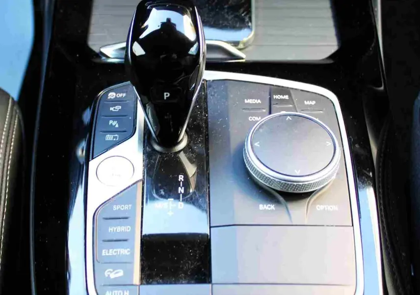 Gros plan sur la console centrale du BMW X3 xDrive 30e 2023, avec levier de vitesses et commandes hybrides visibles.