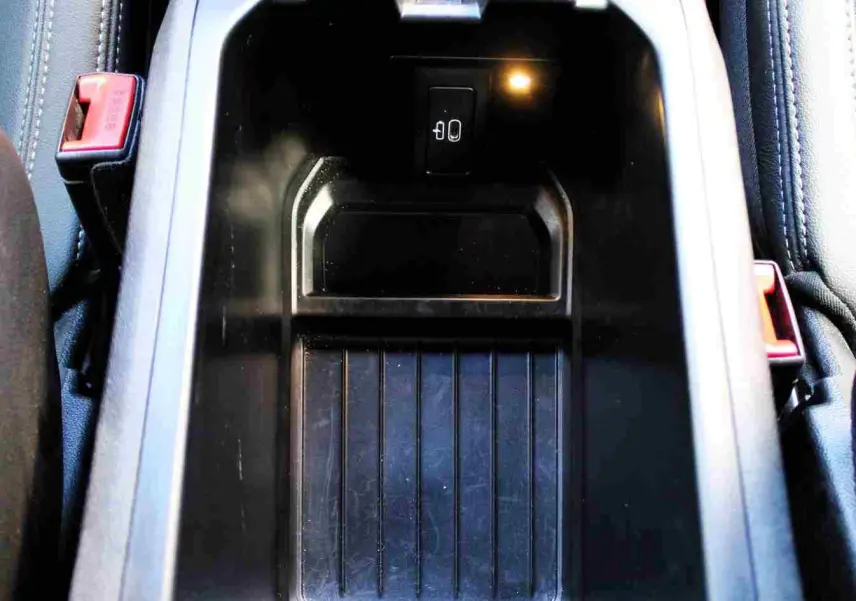 Gros plan sur le rangement central noir du BMW X3 xDrive 30e 2023, avec prise USB visible à l'intérieur.