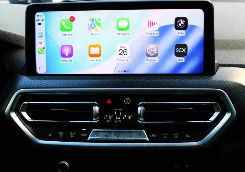 Écran tactile central et commandes de climatisation du BMW X3 xDrive 30e 2023, intérieur moderne et épuré.