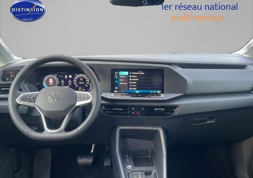 Vue intérieure frontale du tableau de bord noir du Volkswagen Caddy 2.0 TDI 122 DSG7 avec écran tactile et volant multifonction.