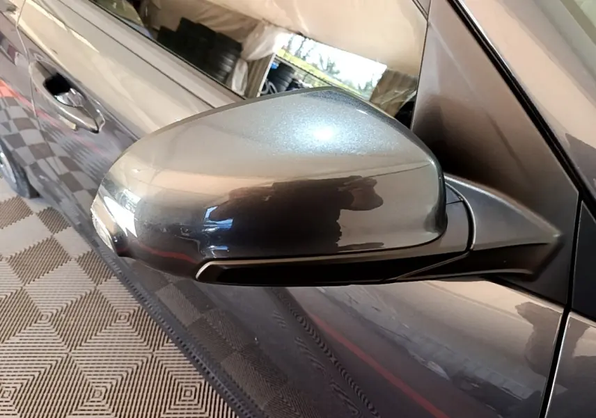 Rétroviseur côté conducteur gris métallisé de Hyundai Kona électrique 2021, vue rapprochée avec portière visible.