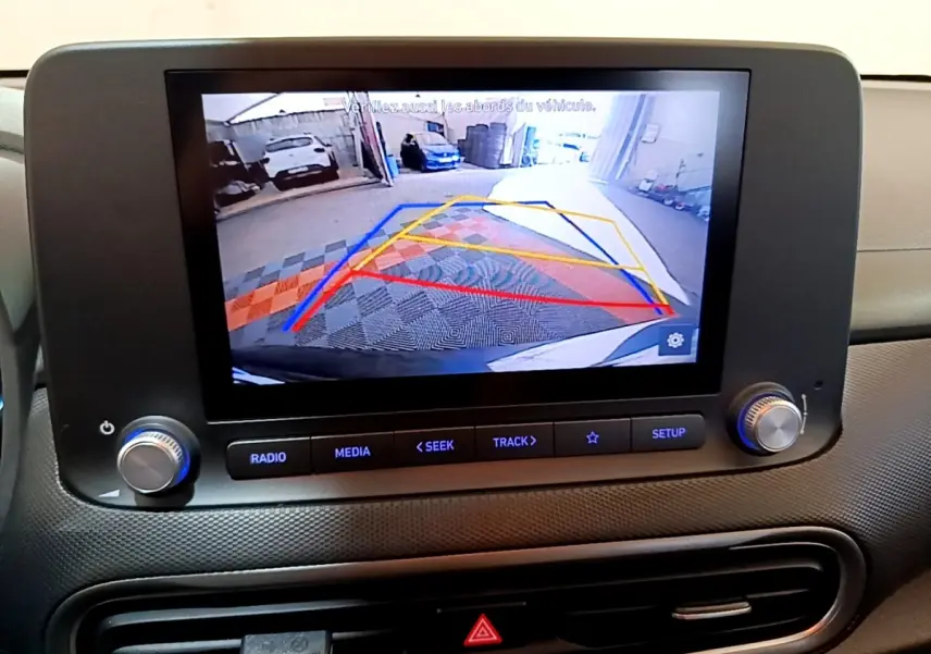 Écran tactile intérieur du Hyundai Kona électrique 2021 montrant la caméra de recul avec guidage coloré.