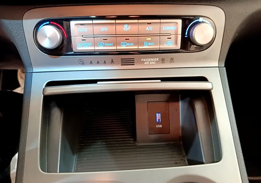 Détail de la console centrale du Hyundai Kona électrique 2021, avec commandes climatisation et port USB visible.