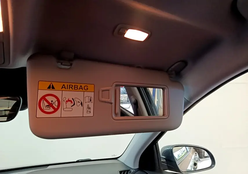Vue intérieure du pare-soleil côté conducteur du Hyundai Kona électrique 2021 avec miroir et avertissement airbag.