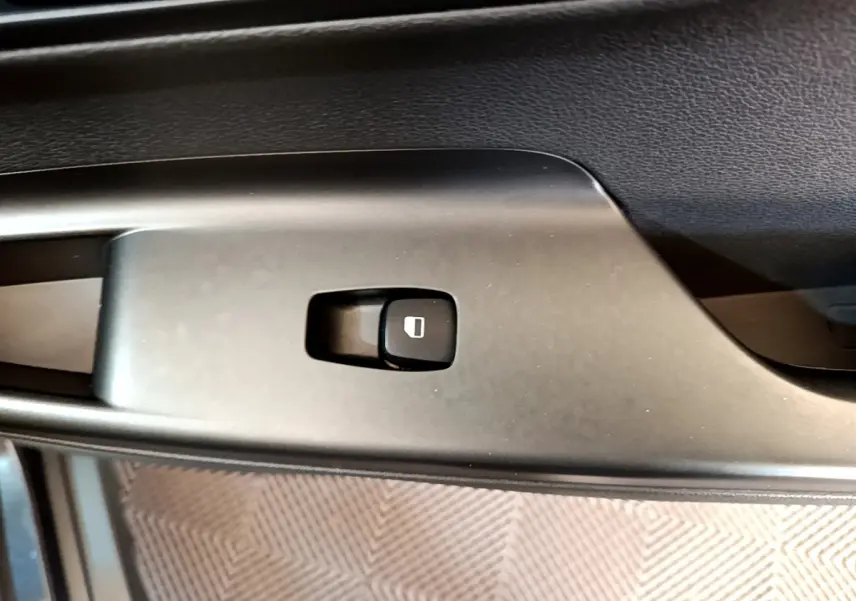 Gros plan sur le bouton de verrouillage des portes sur la portière intérieure noire d’un Hyundai Kona électrique 2021.