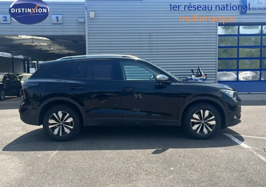 Vue de profil côté gauche du Volkswagen Tiguan noir Grenadilla 2026 avec jantes distinctives et lignes épurées.