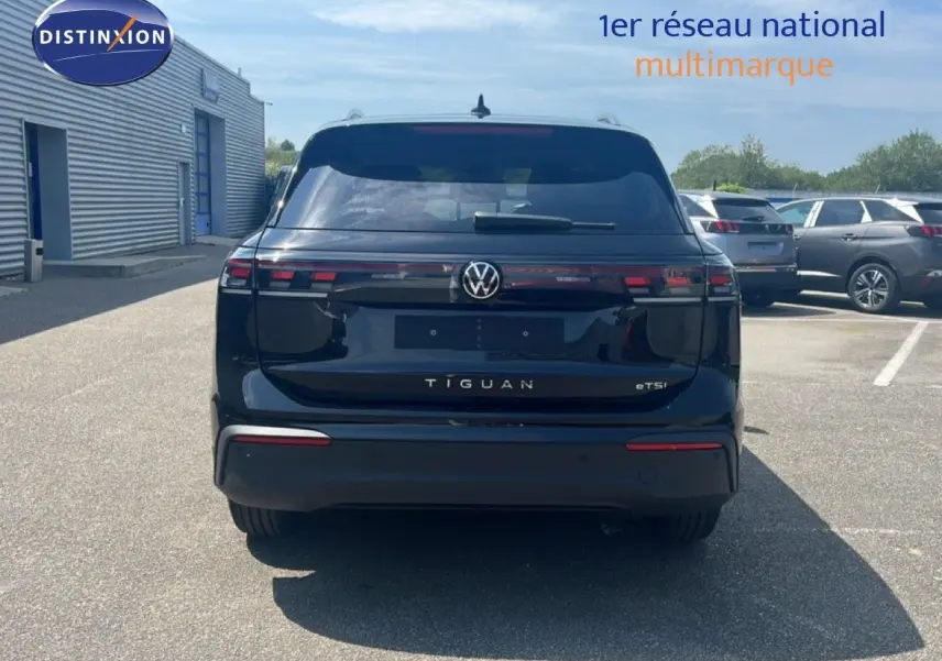 Vue arrière d'un Volkswagen Tiguan noir grenadilla métal 2026 avec logo et feux LED distinctifs.