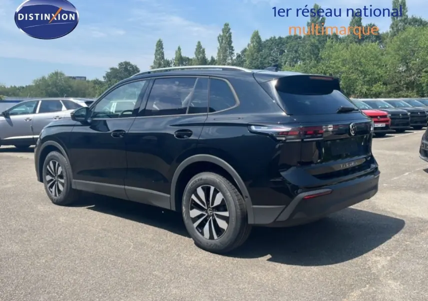 Volkswagen Tiguan noir grenadilla métal vu de trois quarts arrière droit avec jantes alliage et toit argenté.