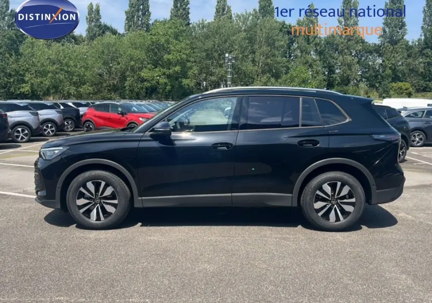 Vue de profil côté gauche d'un Volkswagen Tiguan noir Grenadilla métallisé, avec jantes bi-ton et lignes épurées.