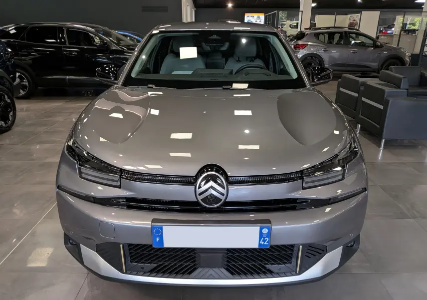 Vue frontale d'une Citroën C4 Hybride 145 CH e-DCS6 MAX gris Mercury, avec calandre noire et éclairage LED fin.