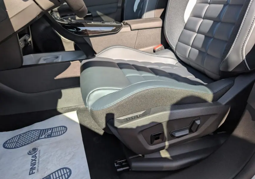 Gros plan sur le siège conducteur avant droit en cuir noir avec réglages électriques dans l'habitacle du Citroën C5 Aircross blanc.