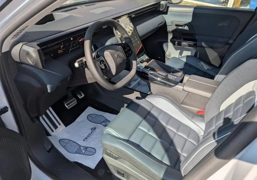 Vue intérieure côté conducteur du Citroën C5 Aircross blanc, avec sellerie cuir et tableau de bord moderne noir.