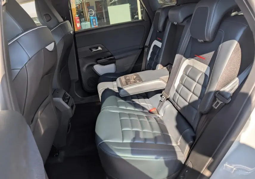 Vue intérieure côté droit des sièges arrière en cuir noir avec accoudoir central déplié du Citroën C5 Aircross blanc.
