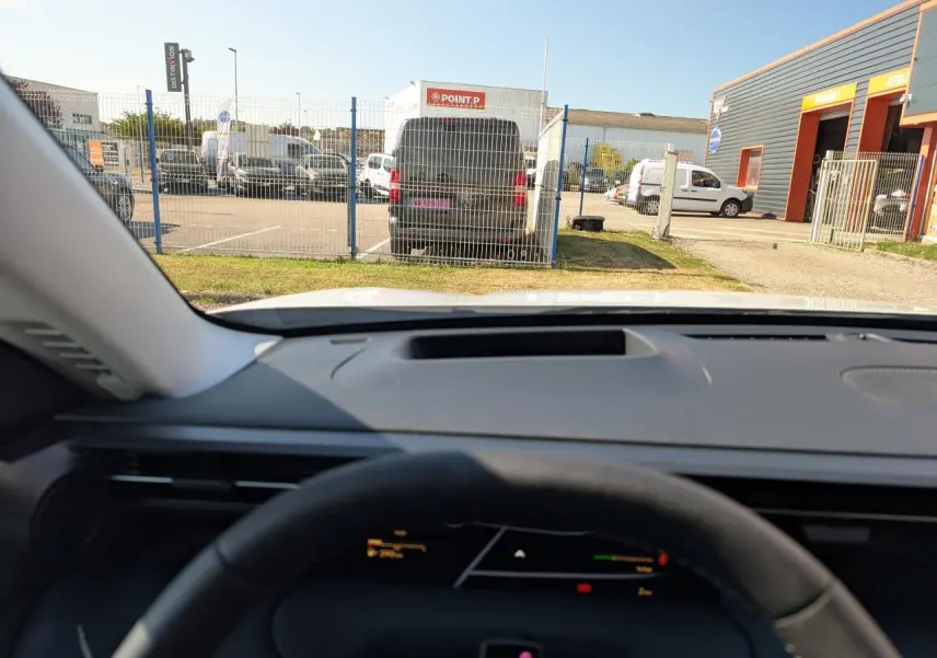 Vue depuis l'intérieur du Citroën C5 Aircross blanc 2026, avec tableau de bord et volant partiellement visibles.
