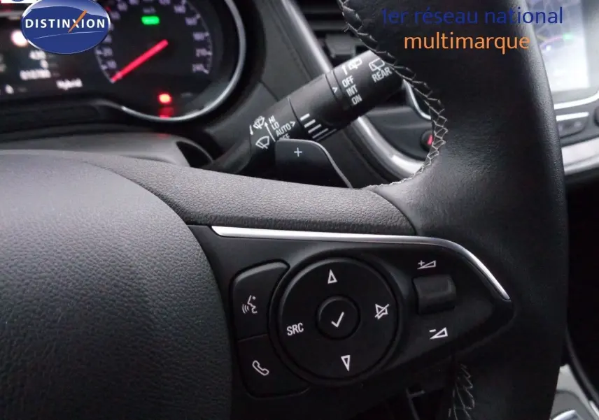 Gros plan sur les commandes au volant en cuir noir de l'Opel Grandland X hybride rechargeable blanc nacré de 2021.