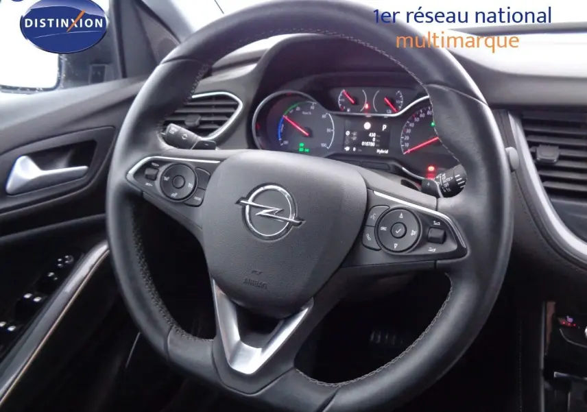 Vue rapprochée du volant en cuir noir de l'Opel Grandland X 1.6 Hybrid Turbo 2021 avec tableau de bord numérique visible.