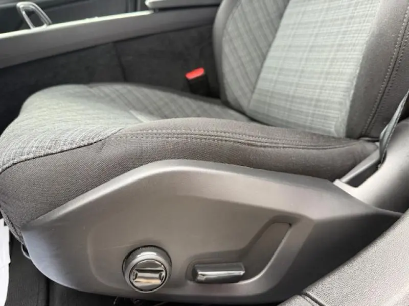 Gros plan sur le siège conducteur en tissu gris à motifs avec réglages électriques dans une Volvo S60 Rouge Fusion Métallisé 2024.