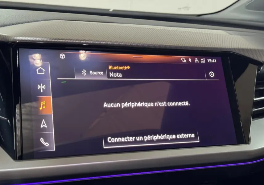 Écran tactile central allumé dans l'habitacle de l'Audi Q4 E-TRON Design Luxe 2022, ambiance lumineuse violette.