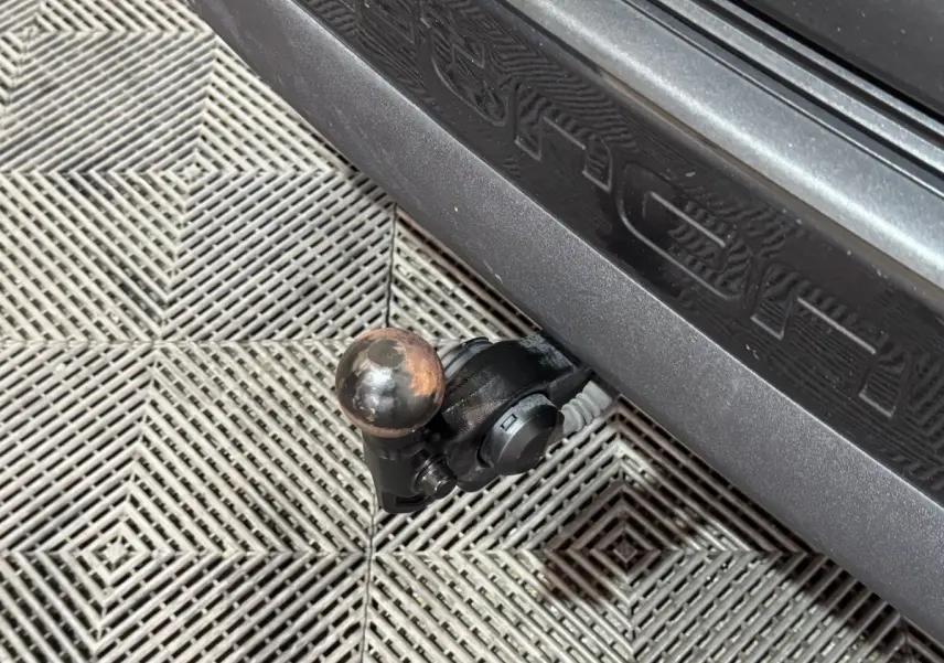 Gros plan sur l'attelage de remorque noir fixé sous le seuil gris foncé de l'Audi Q4 E-TRON Design Luxe 2022.