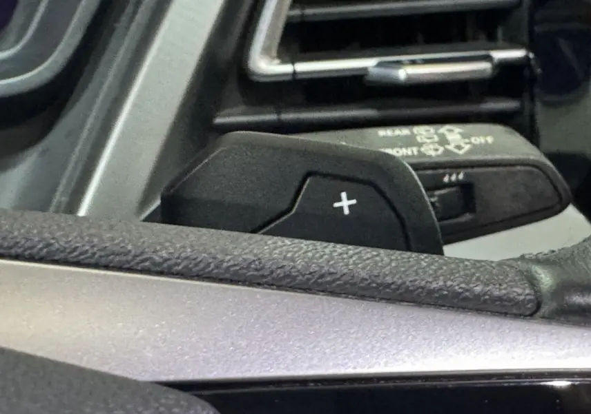 Gros plan sur la palette de changement de vitesse "+" côté gauche du volant dans l'Audi Q4 E-TRON gris foncé 2022.