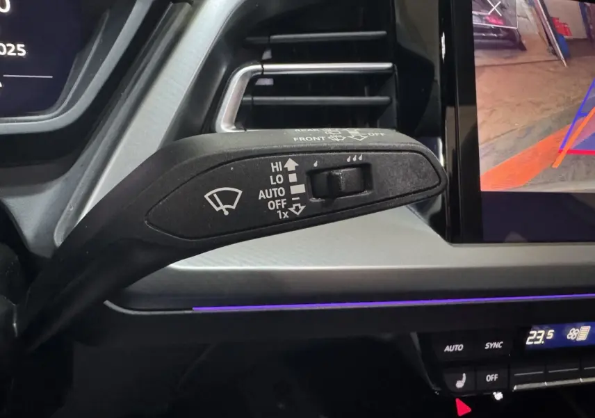 Gros plan sur la commande d’essuie-glace à gauche du tableau de bord gris clair d’un Audi Q4 E-TRON 2022 électrique.