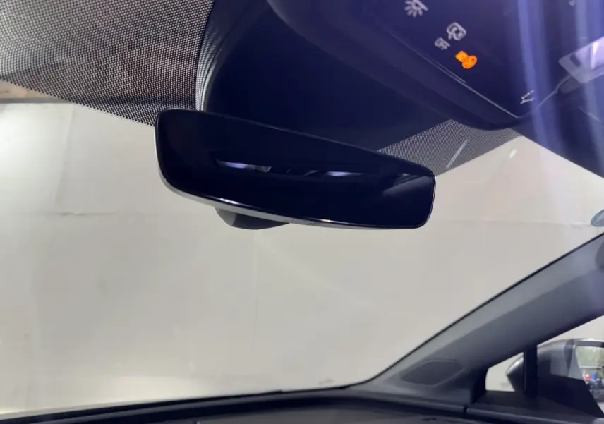 Rétroviseur intérieur noir et tableau de bord supérieur d'un Audi Q4 E-TRON Design Luxe gris foncé, vue de l'habitacle côté conducteur.