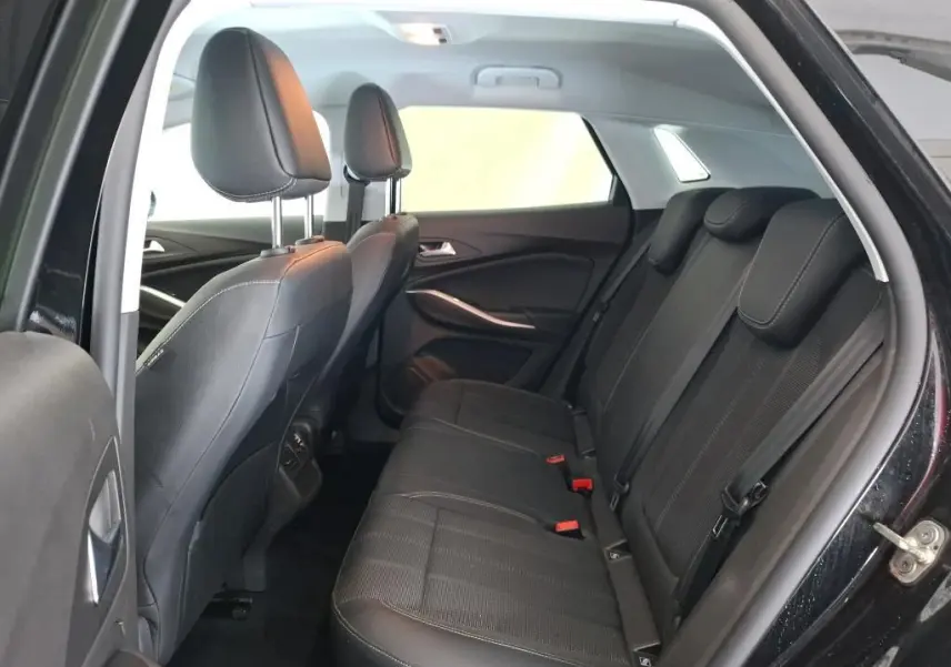 Vue intérieure côté droit des sièges arrière noirs de l’Opel Grandland 2023 avec détails des appuie-têtes et ceintures.