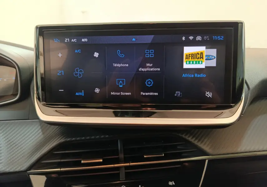 Écran tactile central de 10 pouces affichant la climatisation et les options multimédia dans une Peugeot 208 gris clair.