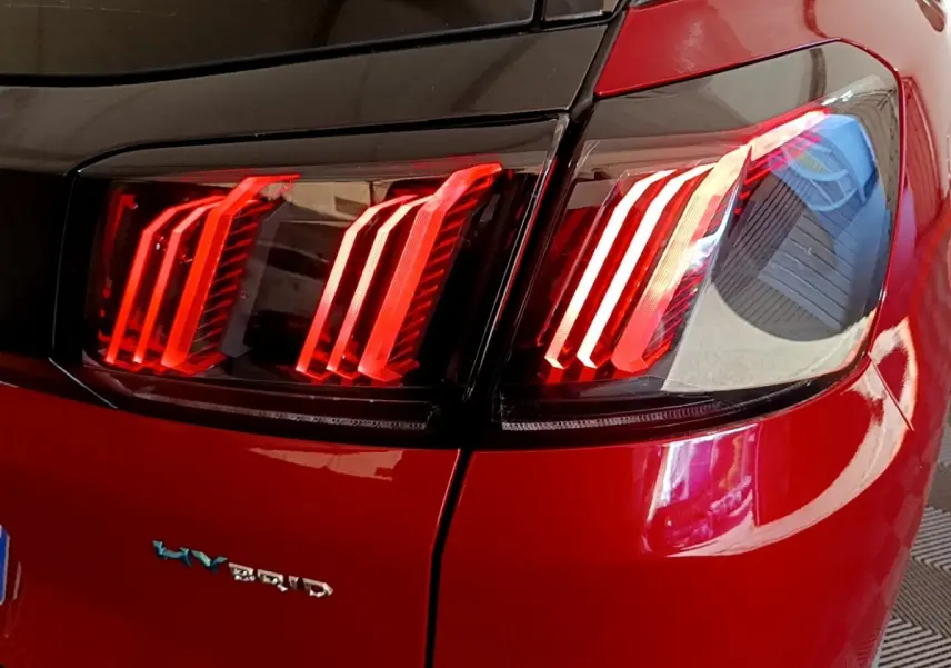 Gros plan sur le feu arrière droit rouge brillant d’un Peugeot 3008 hybride rechargeable de 2021.