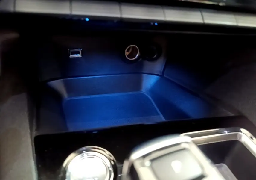 Gros plan sur la console centrale noire avec bouton démarrage et prises USB et allume-cigare du Peugeot 3008 hybride.