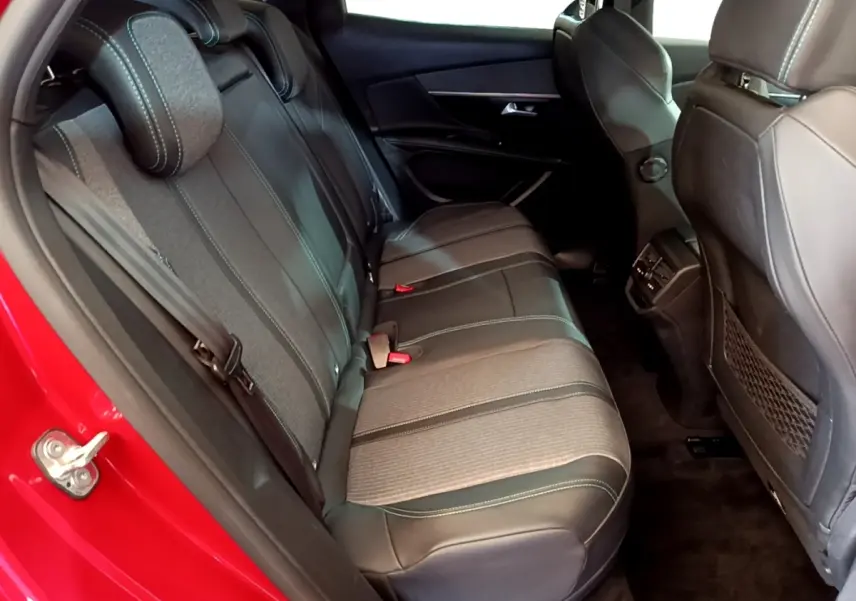 Vue intérieure côté arrière gauche du Peugeot 3008 hybride rechargeable 2021, sièges arrière en tissu et cuir noir avec surpiqûres vertes.