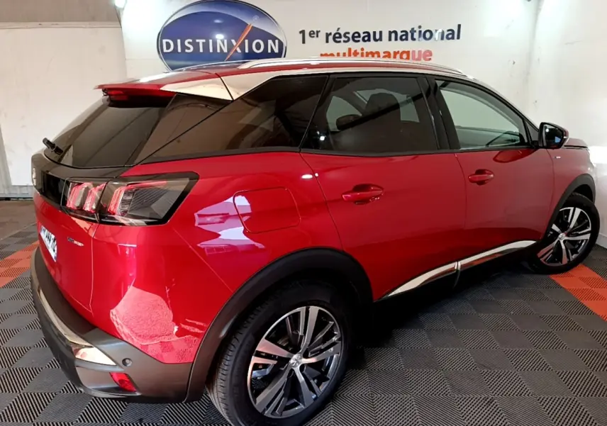 Vue 3/4 arrière droite d’un Peugeot 3008 hybride rechargeable rouge avec toit noir et jantes alliage.