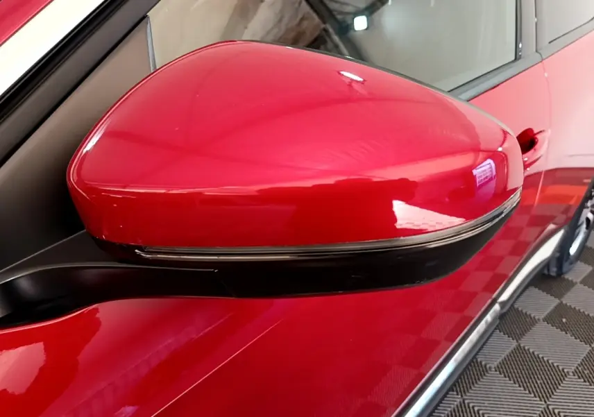 Rétroviseur droit rouge brillant du Peugeot 3008 hybride rechargeable, vue rapprochée sur la portière côté droit.