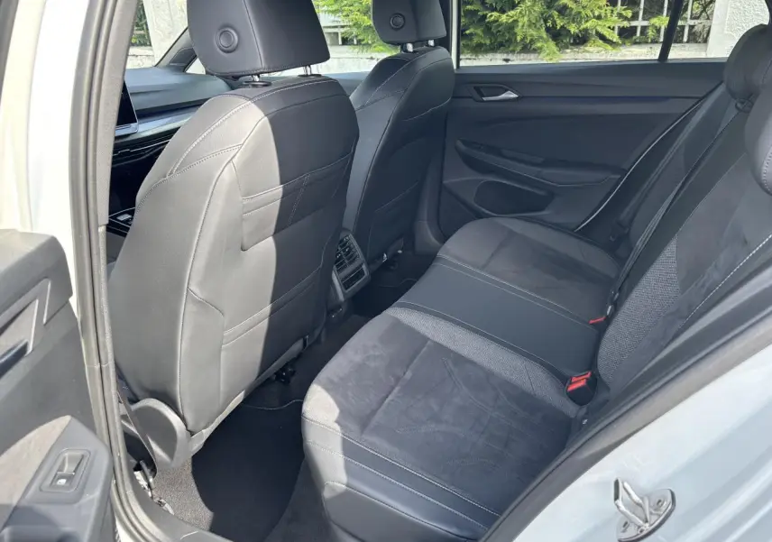 Vue intérieure arrière côté droit de la Volkswagen Golf 1.5 eTSI Edition 50 2024 avec sièges en cuir et tissu noirs.
