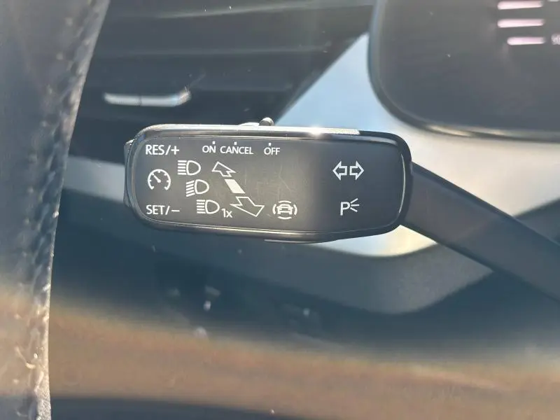 Le levier de commande noir du régulateur de vitesse et des feux dans l'habitacle du Skoda Kamiq noir Magic nacré 2023.