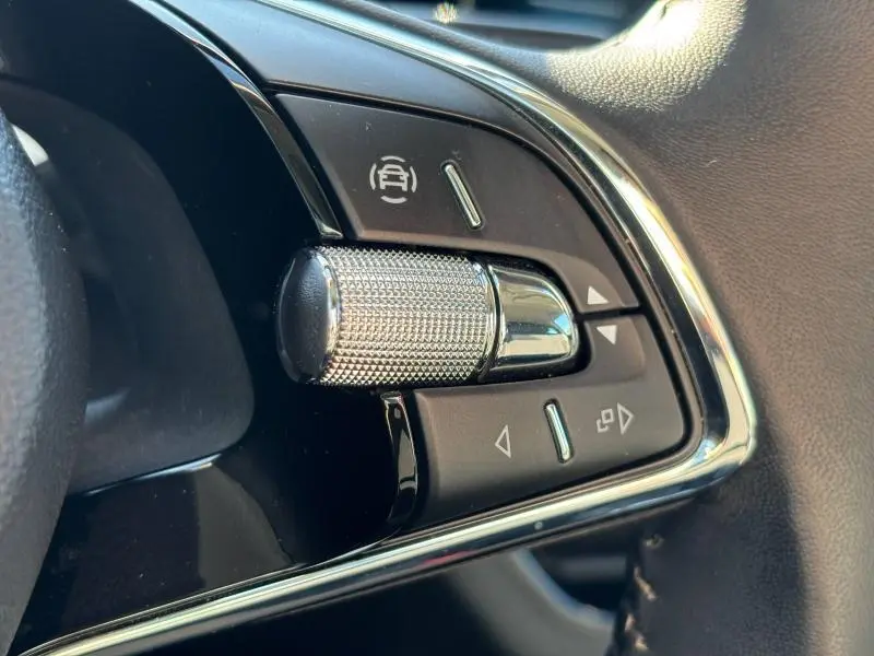 Gros plan sur les commandes en chrome et noir du volant cuir multifonction du Skoda Kamiq 2023 noir Magic nacré