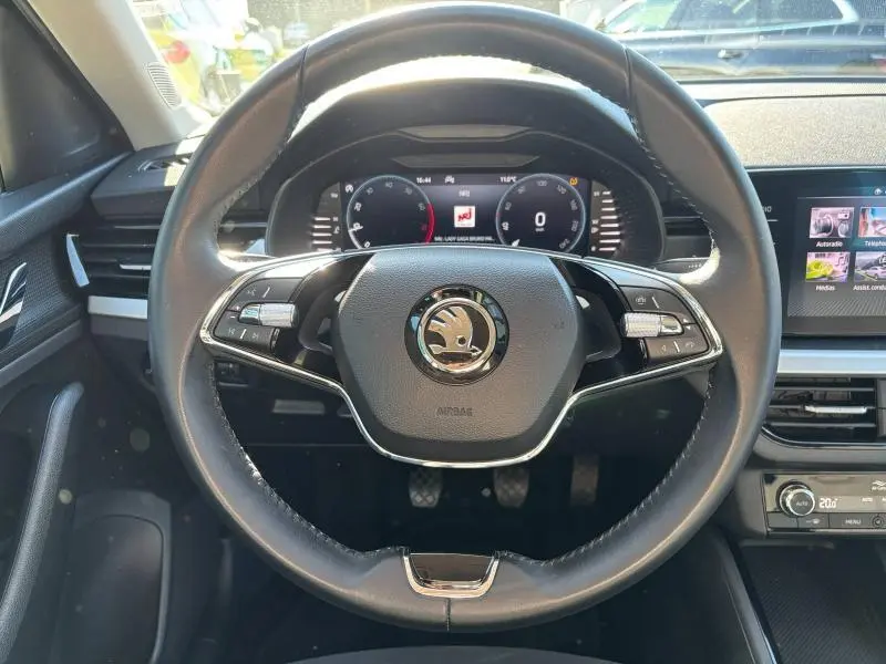 Vue rapprochée du volant cuir multifonction noir d'un Skoda Kamiq 2023 avec tableau de bord numérique et écran tactile.