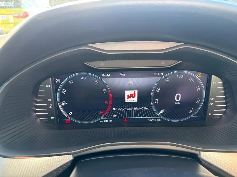 Tableau de bord numérique du Skoda Kamiq 1.5 TSI 2023 affichant la vitesse à 0 km/h et la radio NRJ.