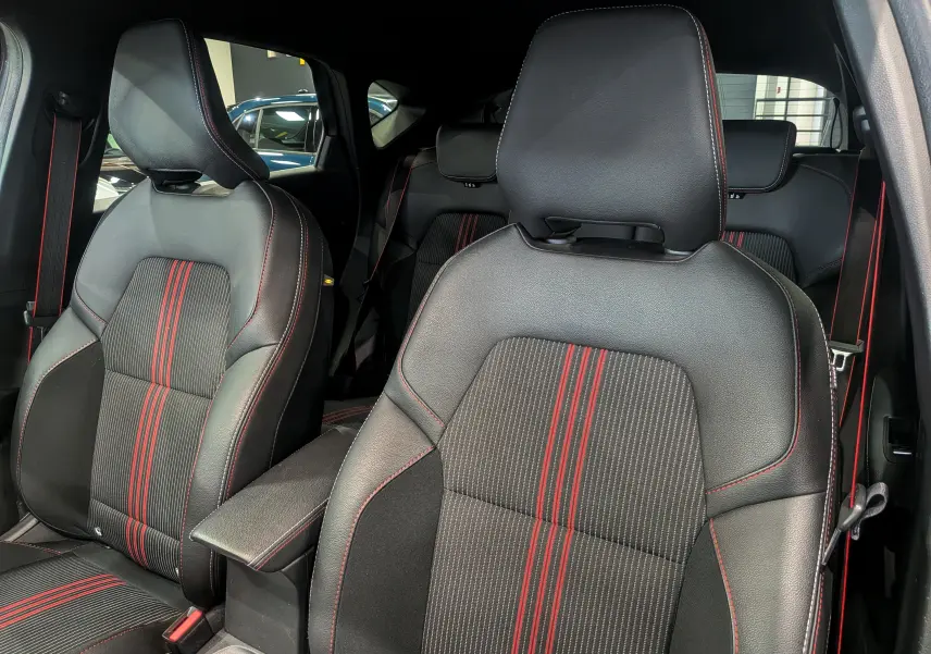 Vue intérieure sur les sièges avant en cuir noir avec surpiqûres rouges du Renault Captur TCe 160 R.S. Line 2022.